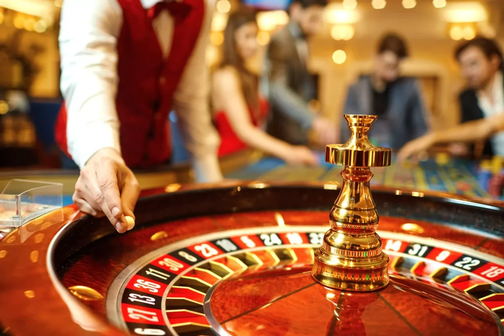 Krupier trzyma w dłoni kulkę ruletki w kasynie.