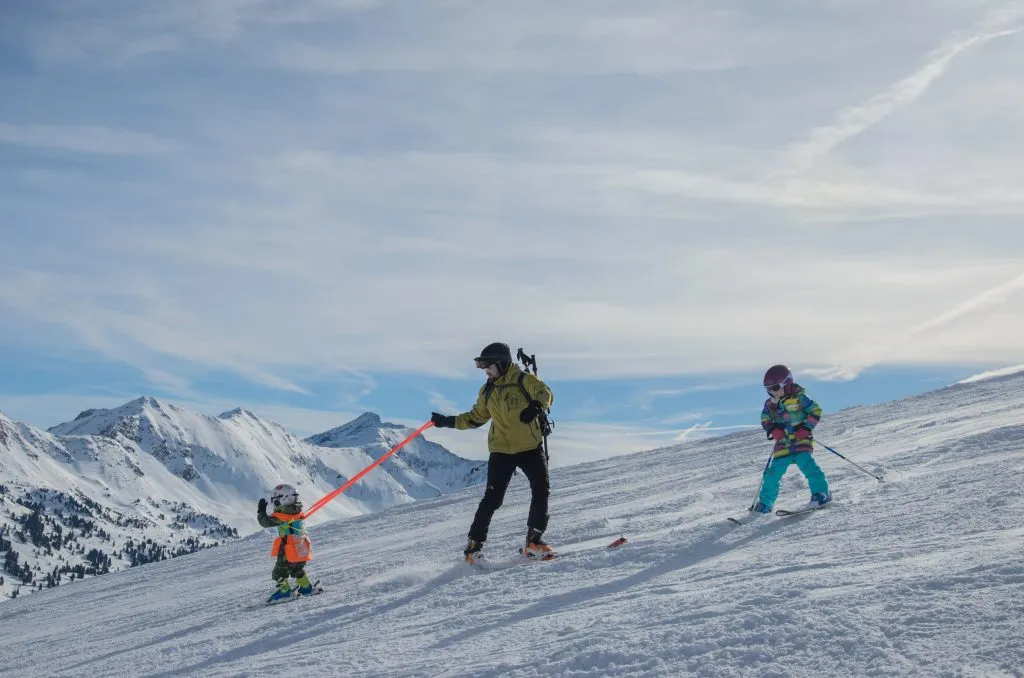 Vista mozzafiato sulle montagne e sulla famiglia di sciatori nel comprensorio sciistico di Obertauern