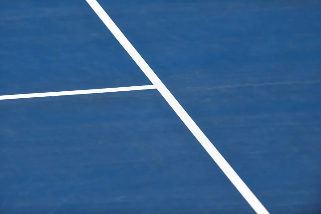 Lignes blanches sur un court de tennis bleu