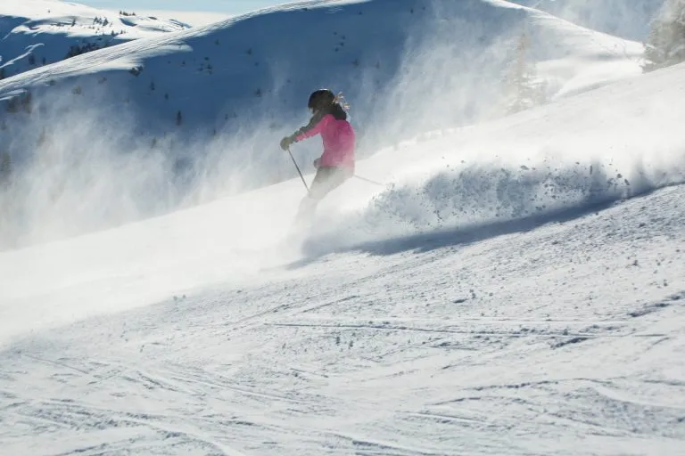 Sci ad alta velocità lungo la pista. Pista da sci in una giornata di sole invernale nella stazione sciistica alpina