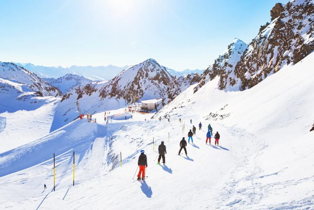 hiihtäjiä kauniilla laskettelurinteellä Alpeilla, ihmisiä talvilomalla