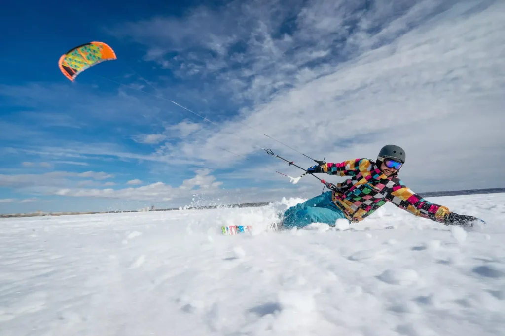 Sportowiec uprawia kiting na tle śniegu i pogodnego nieba Syberii