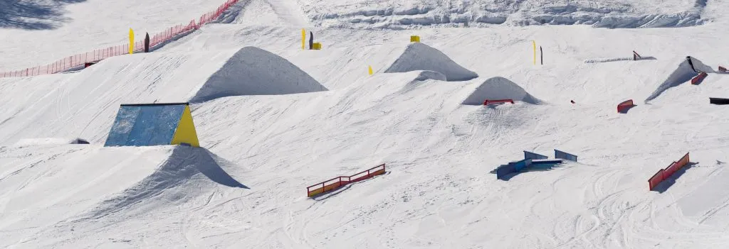 Snowpark avec rampes de ski, kickers, rails pour les sauts big air, jibbing, etc. des snowboarders et skieurs freestyle.