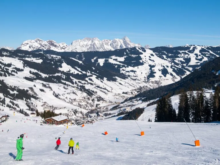 Pista di discesa e rifugio apres ski con terrazza ristorante nella stazione invernale di Saalbach Hinterglemm Leogang, Tirolo, Austria, Europa. Scatto di una giornata di sole.